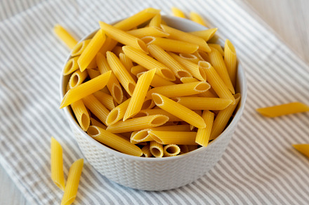 Uncooked Organic Penne Pasta in a Bowl, side view., a Food & Drink Photo by LiudmylaChuhunova