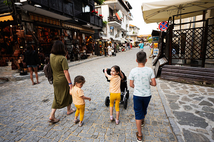 Family walking in the street of the old town of Nessebar., a Person Photo by AS photostudio