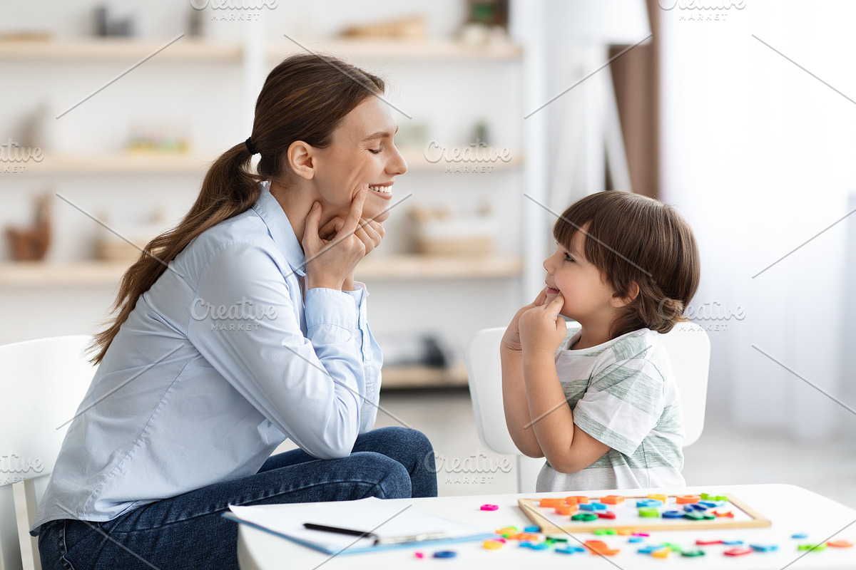 Professional woman specialist training with cute little boy, showing him oral e, a Photo by Prostock-Studio (Photo 1 of 2)