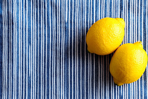 Two fresh yellow lemons on a blue, a Food & Drink Photo by MistyDay