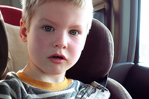 Cute boy in a child car seat containing boy, child, and look out the window