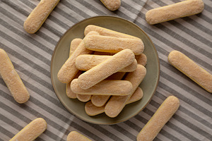 Savoiardi biscuits on a plate, top view., a Food & Drink Photo by LiudmylaChuhunova