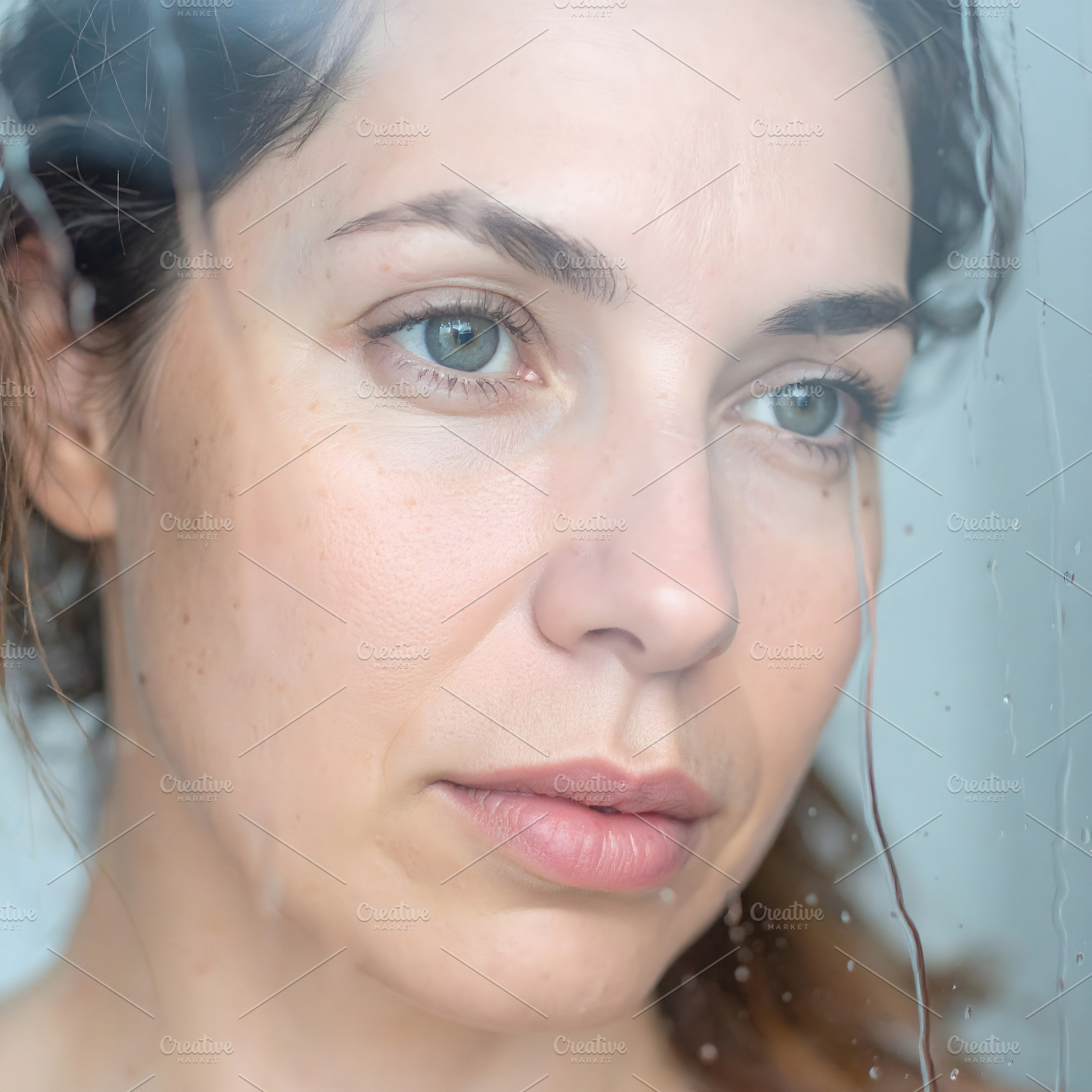Woman with curly hair staring out window on rainy day, a Person Photo by GoodGoods