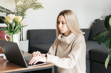 Young woman working on laptop in  home, a Person Photo by Olena Rudo