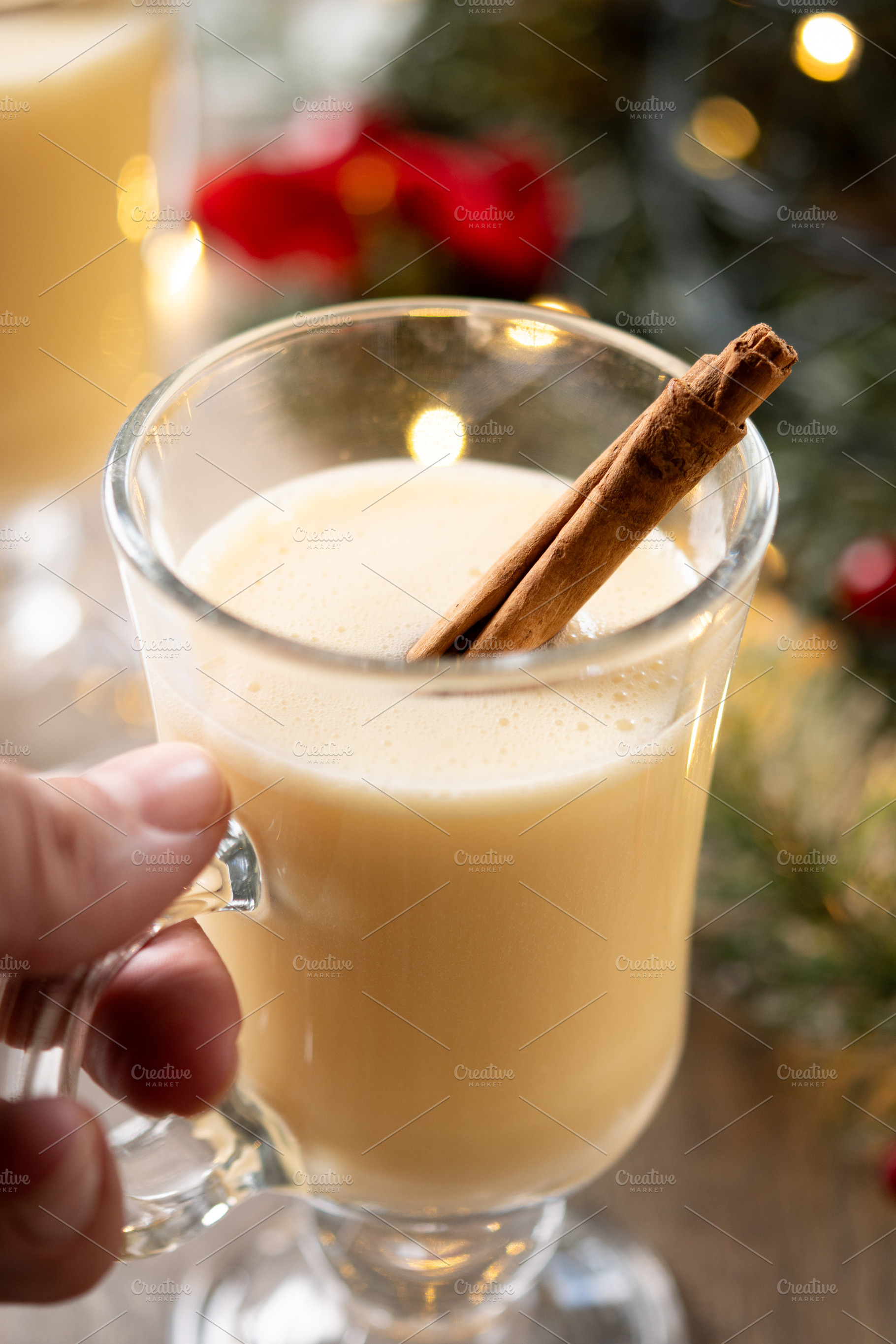 Hand picking up a glass of eggnog from a Christmas table, a Food & Drink Photo by etorres69