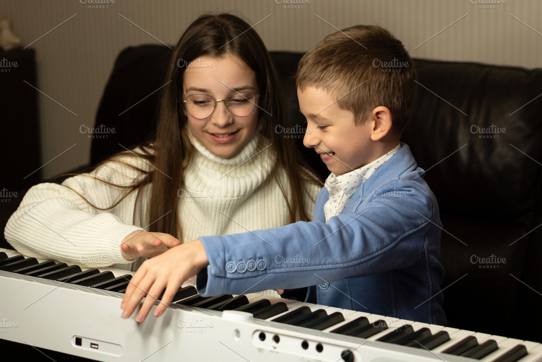 Young boy and teen girl play piano, a School & Education Photo by Elena Vagengeim