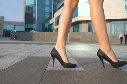 Female legs in high heels shoes walking in the urban street feet of young