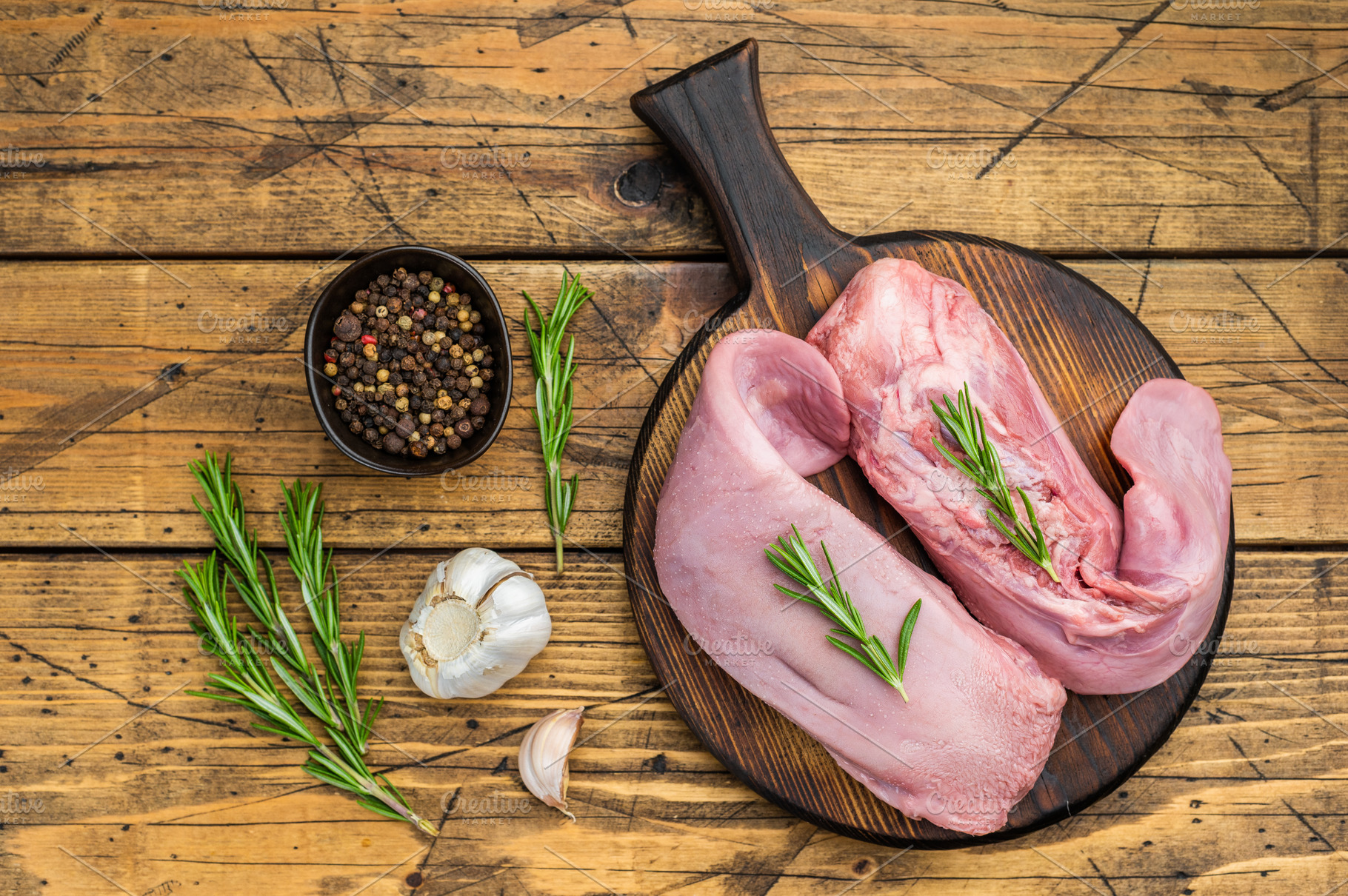 Fresh uncooked pork tongue arranged on round wooden board with h, a Food & Drink Photo by composter-box@mail.ru