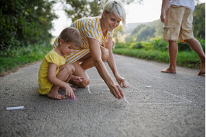 Mom and girl drawing with chalk on, a Person Photo by HalfPoint