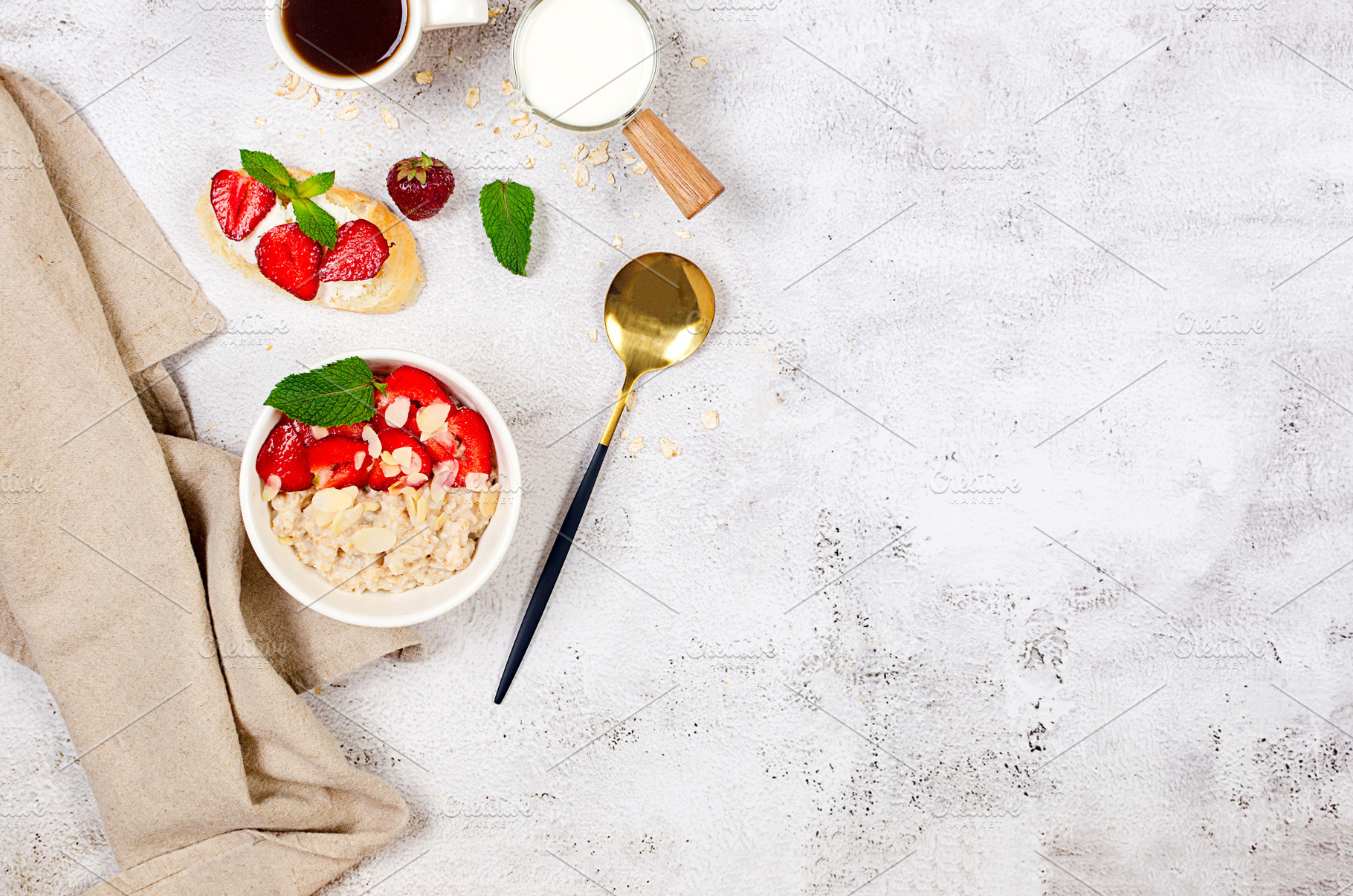 A bowl of oatmeal with strawberries and almond flakes on a table, a Food & Drink Photo by vimart