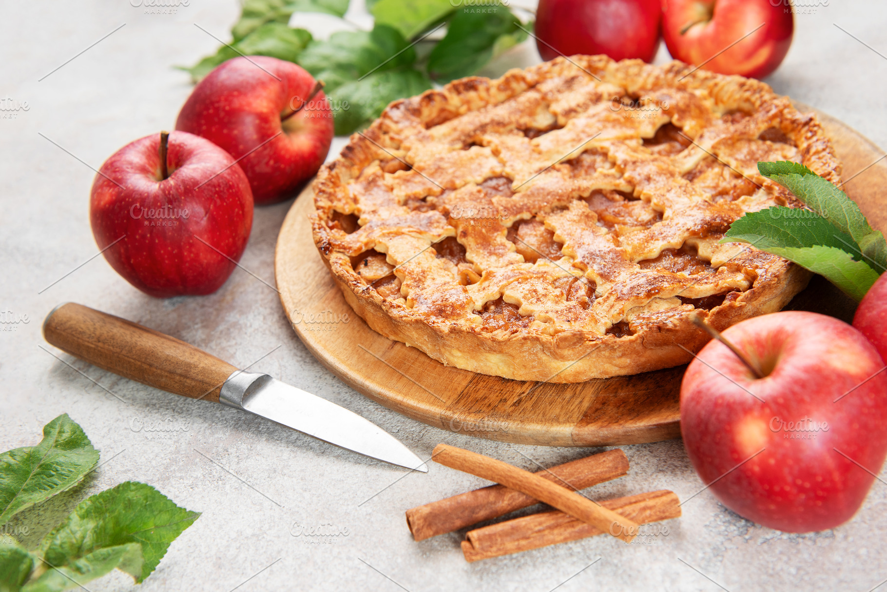 Freshly baked apple pie decorated with cinnamon sticks and apple, a Food & Drink Photo by Olena Rudo