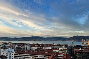 Panoramic view of Vigo city skyline with bay and surrounding hills under a vivi, a Photo by AS photostudio