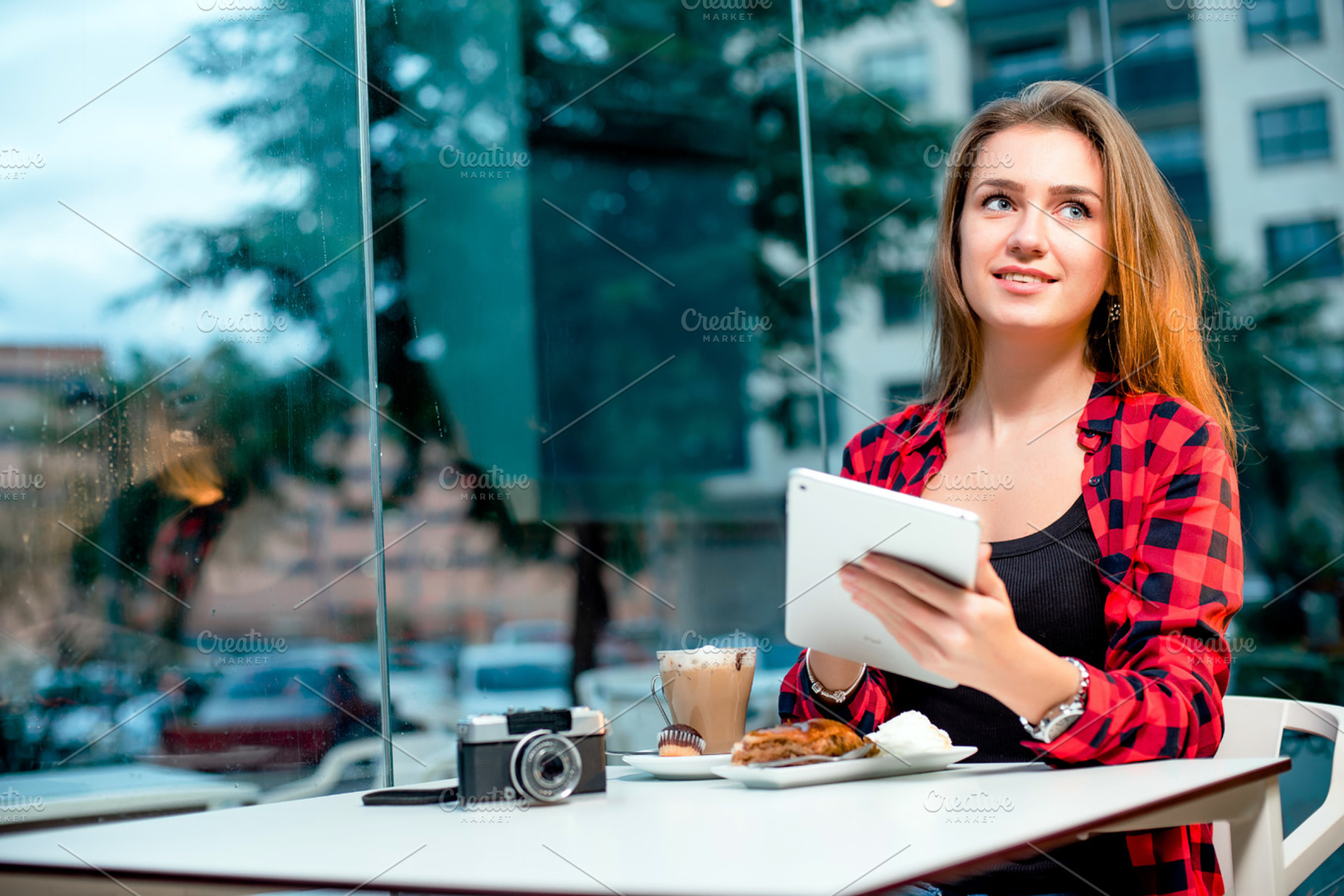 Young happy woman with a tablet sitting in cafe containing music, woman, and, a Person Photo by BodiaPhoto
