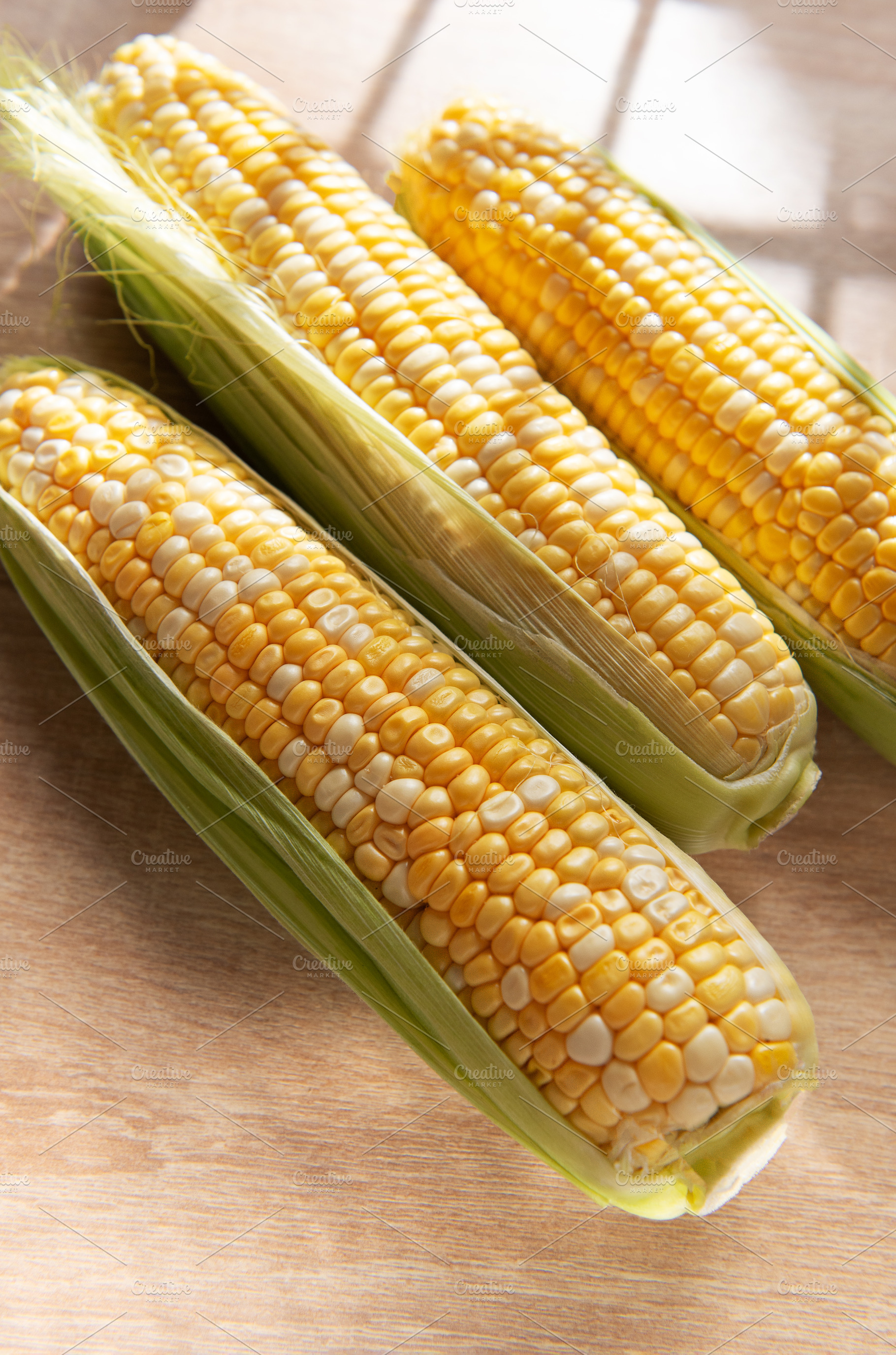 Fresh organic sweet corn on wooden table, a Food & Drink Photo by Olena Rudo