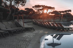 Sunset poolside with empty loungers, a Sports & Recreation Photo by SkyNext