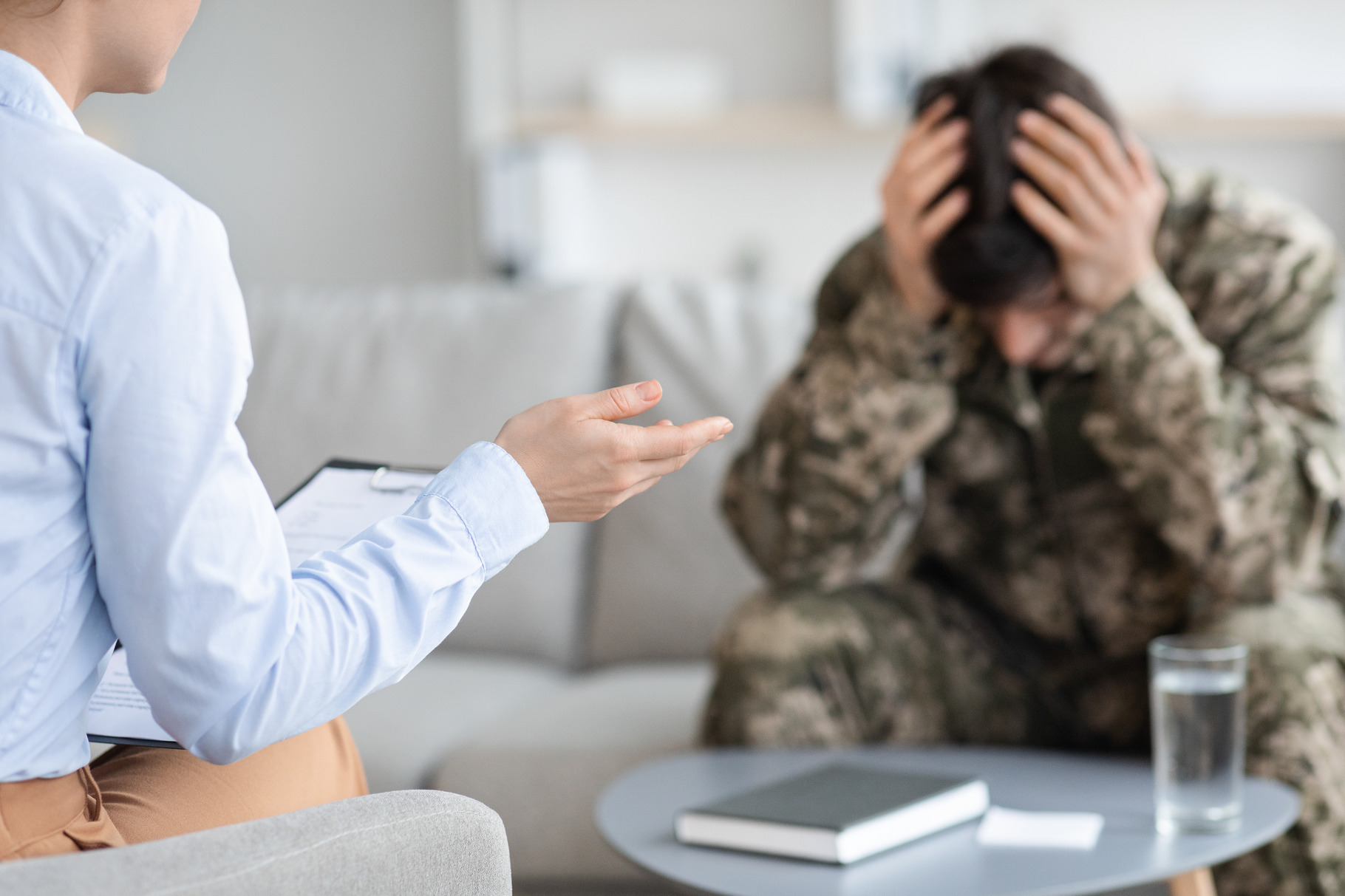 Unrecognizable lady psychologist having conversation with soldier, a ...