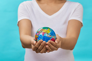 Woman holding globe in her hands featuring earth, hand, and person