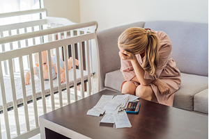 Mother sitting on sofa calculating, a Business Photo by Elizaveta Galitskaya