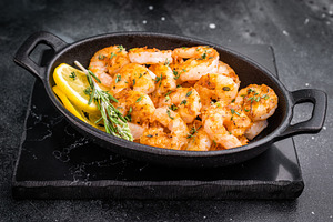 Grilled shrimps prawns in a cast iron skillet on a black slate s, a Food & Drink Photo by composter-box@mail.ru
