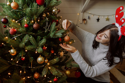 Girl in reindeer hat decorating tree, a Holiday Photo by Sonjachni