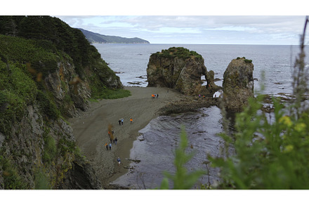 People on shore with rocks and arch, a Nature Photo by Media Whale Stock