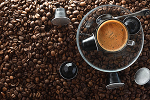 Coffee on glass plate in center on beans and capsules, a Food & Drink Photo by Davizro's Market