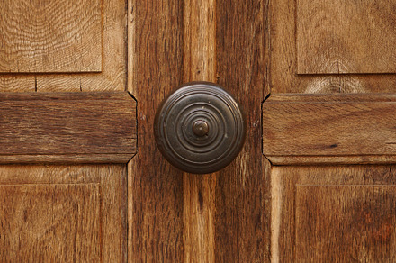 Old wooden door with metal bell
