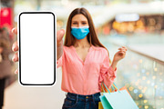 Woman Showing Big Smartphone Screen Wearing Face Mask In Mall, a Photo by Prostock-Studio (Thumbnail 2 of 2)