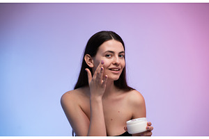 Young woman applying face cream, a Health & Medical Photo by volodymyrshtun13795