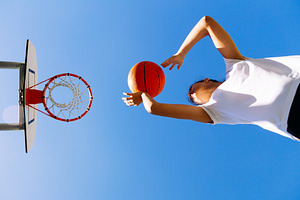 Young girl shooting basket outdoors featuring basketball, sport, and teen