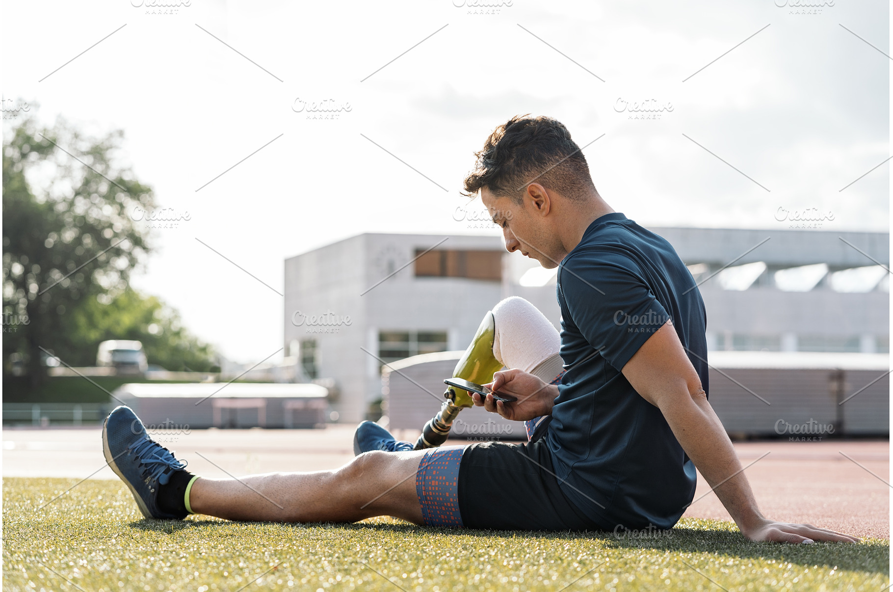 Disabled athlete sitting using phone, a Sports & Recreation Photo by nunezimage