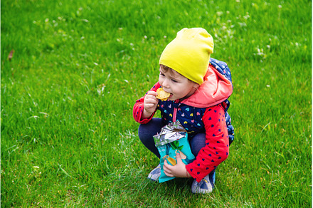 The child eats chips in the park, a Person Photo by yanadjana
