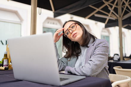 Tired business woman in stress works at laptop, a Photo by andreonegin market