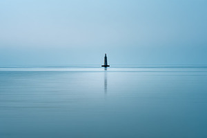 Lighthouse stands in calm waters, a Photo by Beautiful things