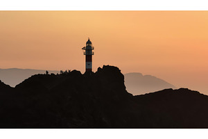 Tourists watching sunset at Faro de, an Architecture Photo by Goinyk