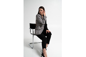 Woman sitting on a modern chair in a, a Business Photo by volodymyrshtun13795