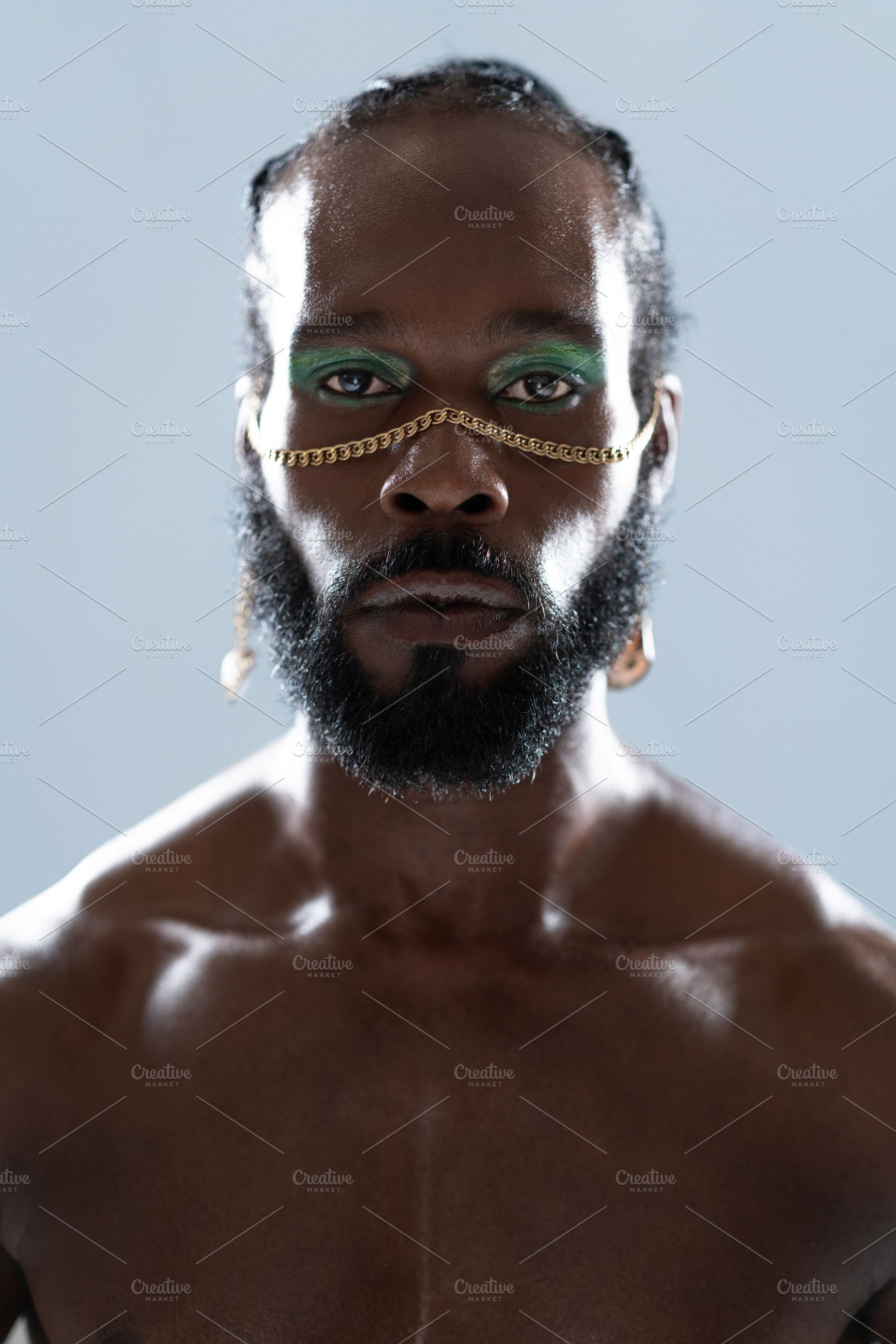 Serious African American shirtless gay model with blue eye makeup, a Person Photo by andreonegin market