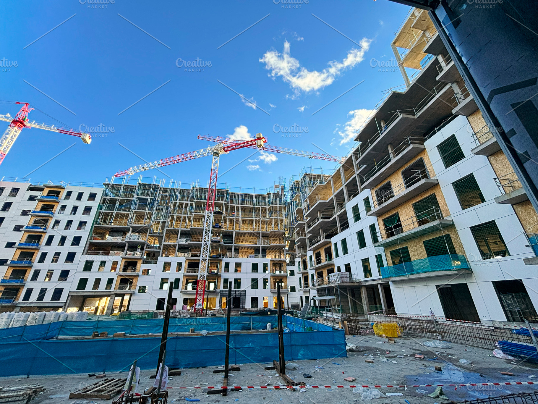 Construction site building cranes moving on a sunny day, an Industrial Photo by karrastock