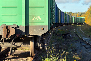 A close-up view of a green freight train car on tracks, with a long line of tra, an Industrial Photo by Textures & Backgrounds