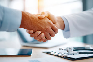 Doctor and patient handshake in medical office, a Business Photo by AlyaAnd