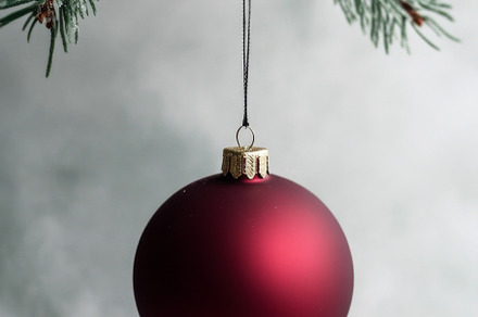 Red Christmas ornament hanging from Christmas tree branch, suita, a Photo by Dvoevnore photos