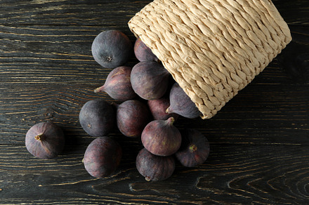 Wicker pot with fig on rustic wooden background, a Food & Drink Photo by AtlasStudio PRO