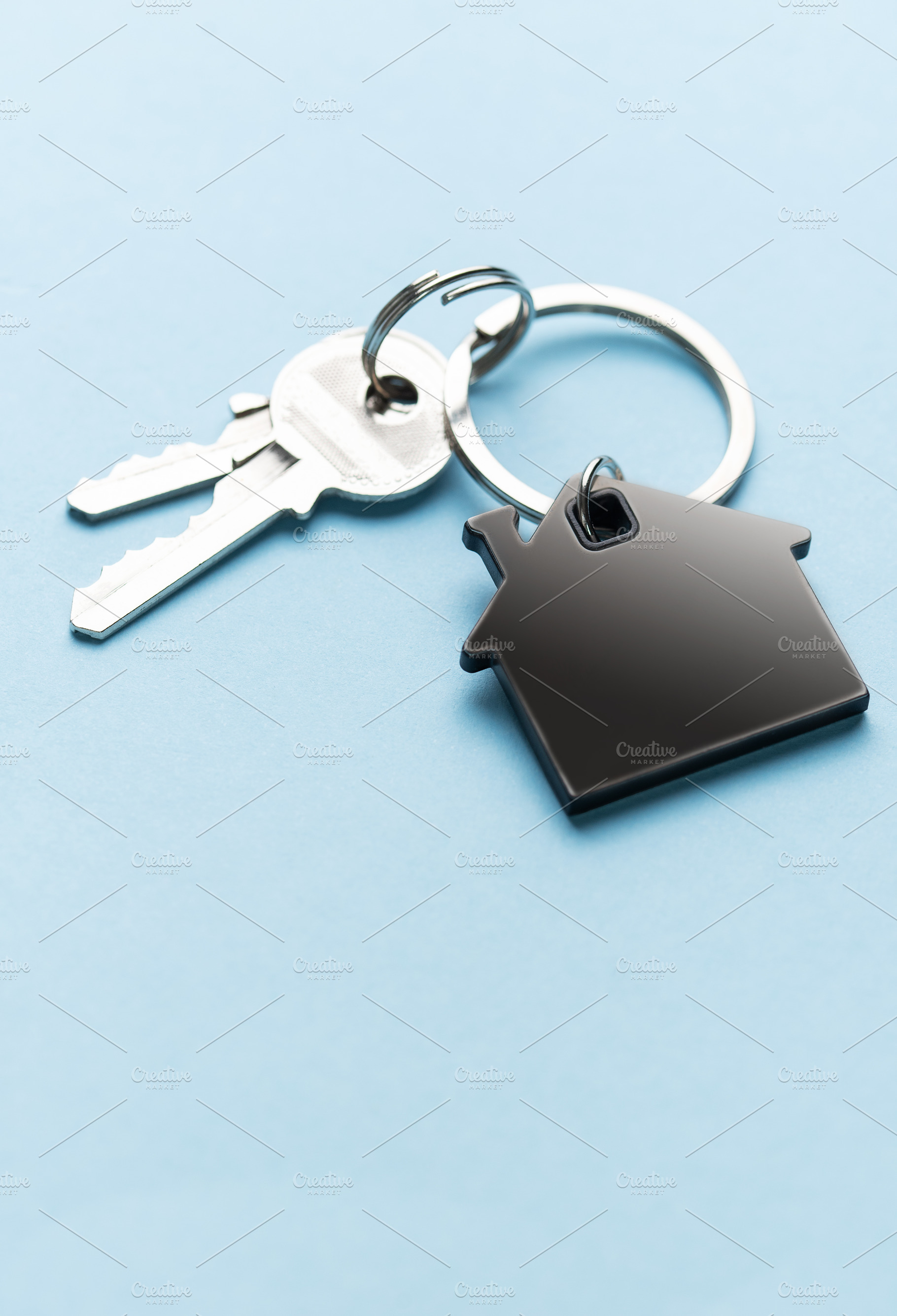 House keys with home shape keychain on blue background, a Business Photo by Olena Rudo