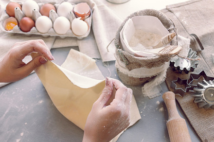 Female hands smooth the dough