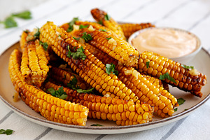 Homemade Spicy Corn Ribs with Mayo on a Plate, side view. Close-, a Food & Drink Photo by LiudmylaChuhunova