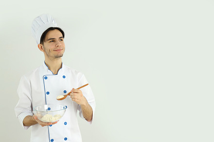 Concept of cooking, young man chef on light background, a Person Photo by AtlasStudio PRO