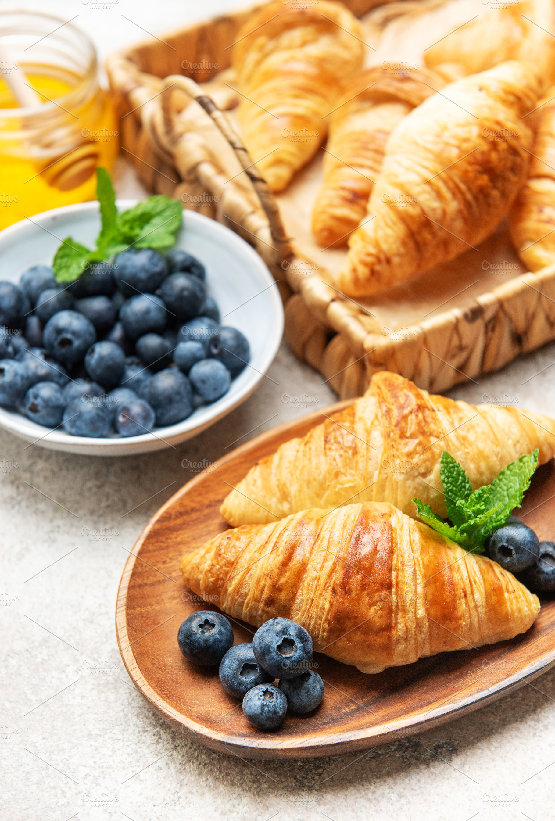 Delicious french croissants with fresh blueberries and honey for, a Food & Drink Photo by Olena Rudo