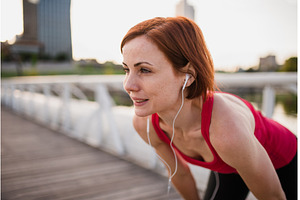 Young woman runner with earphones in, a Person Photo by HalfPoint