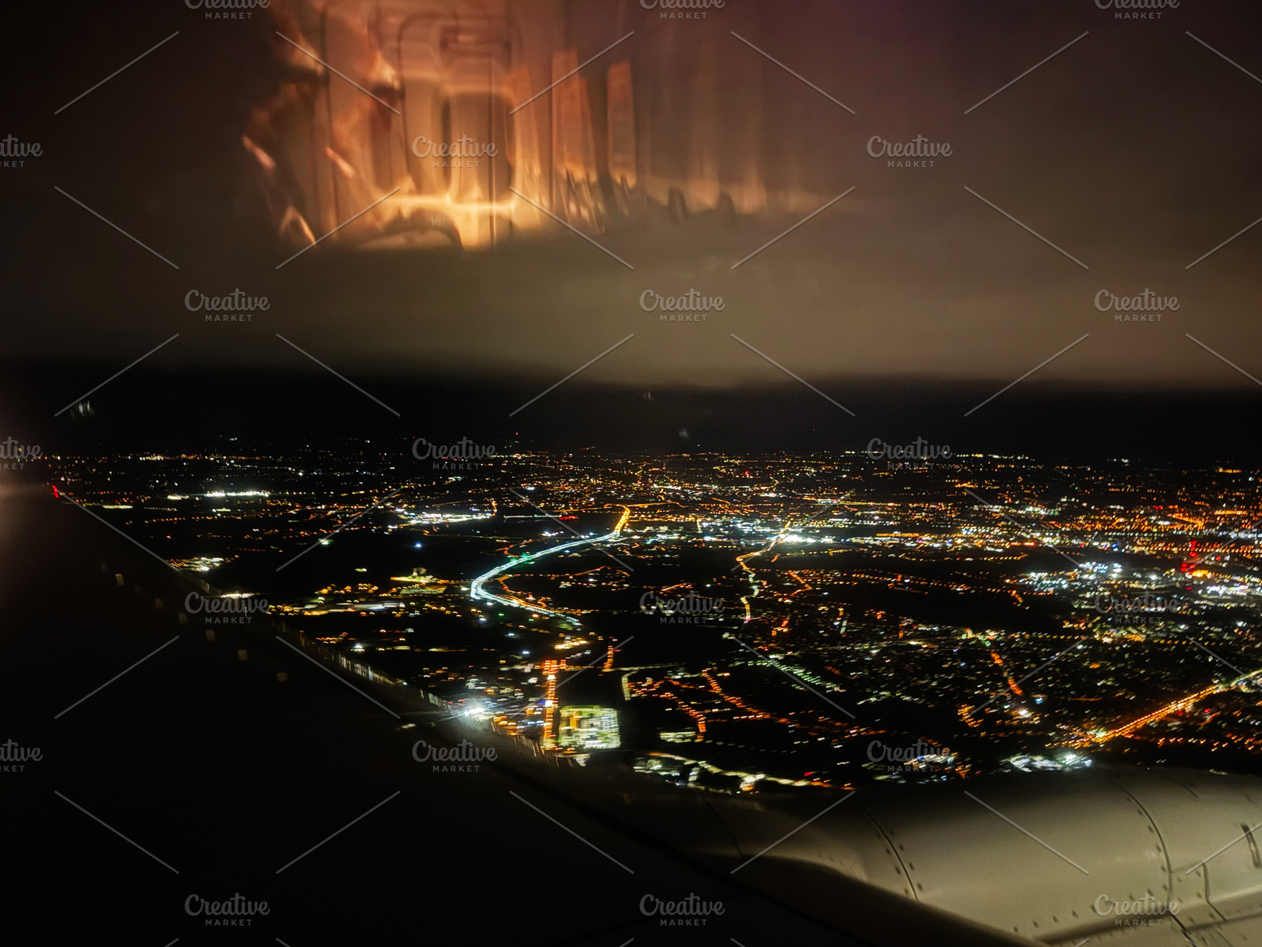 Stunning night aerial view of Krakow city lights from an airplane window over P, a Photo by AS photostudio