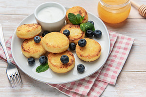 Sirniki cheese pancakes with blueberries honey and sour cream, a Food & Drink Photo by Olena Rudo